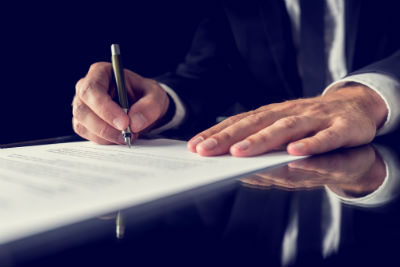 Close Up of Hands Signing Papers