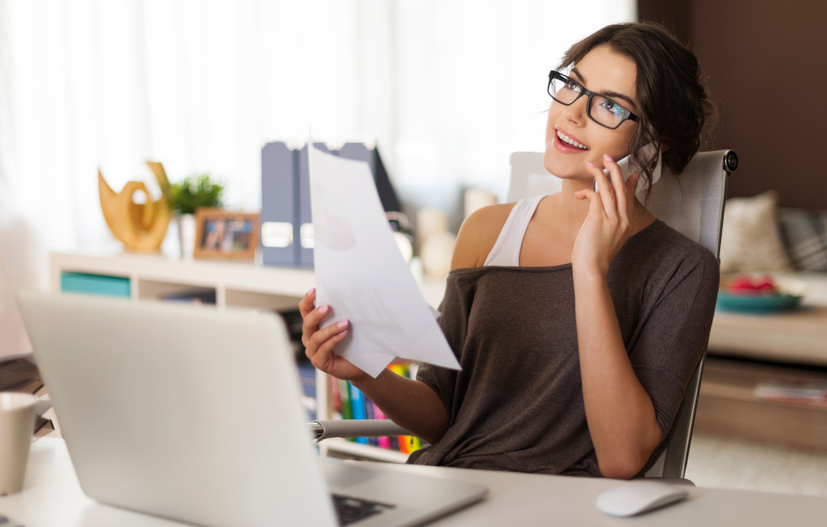 Woman talking on phone and working on laptop