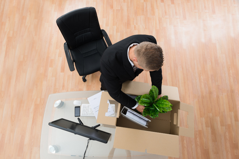 Business Man Putting Desk Items Into a Moving Box