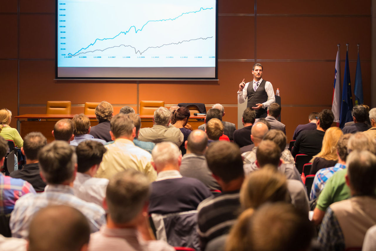 A male speaker giving a speech at a conference event