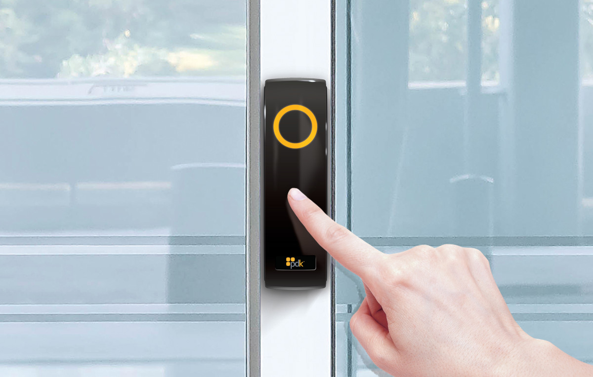 Close up of a hand pressing on access control system that is keeping a glass door locked