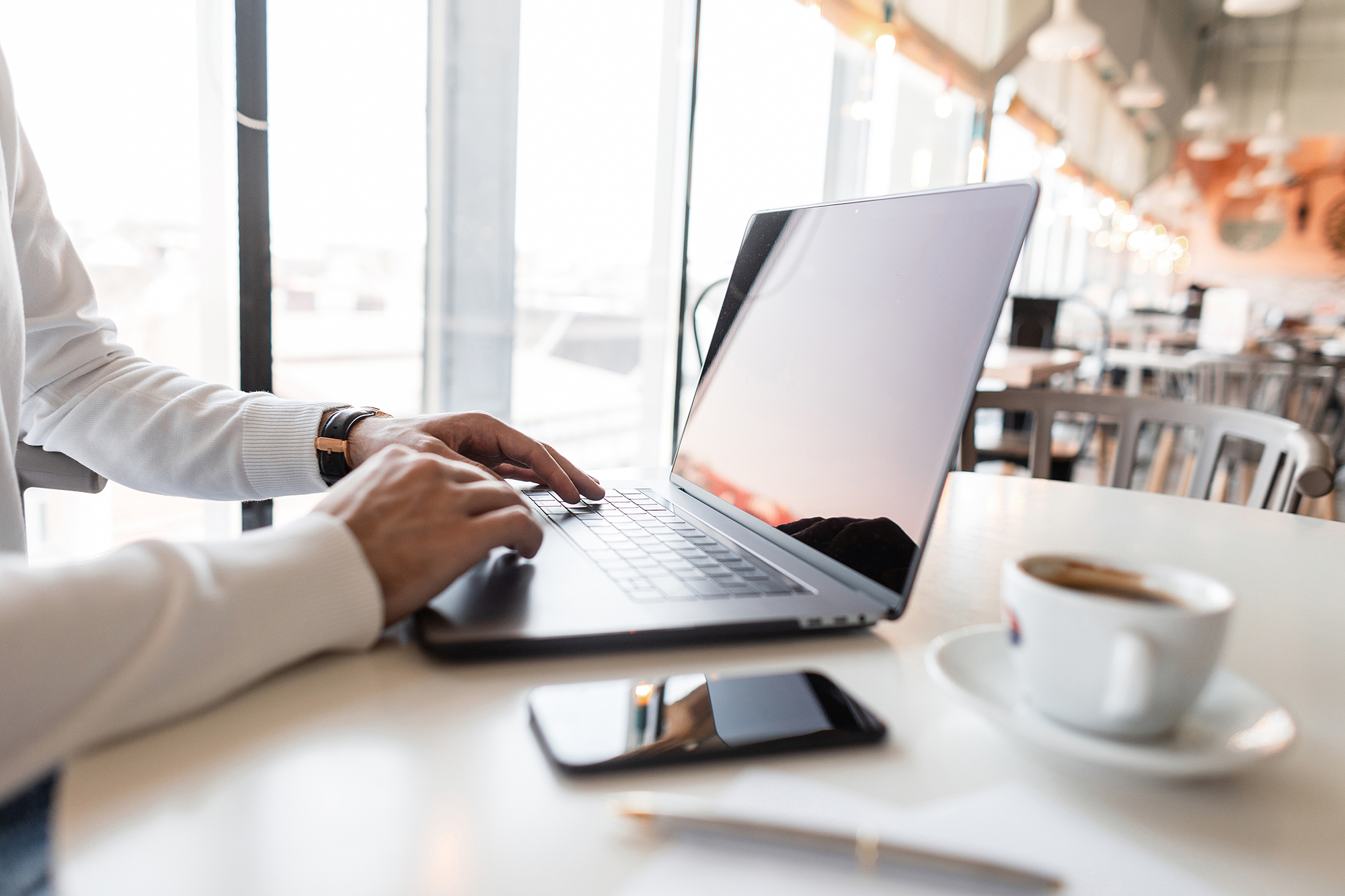 Close-up of a laptop someone is using while in a cofffe shop